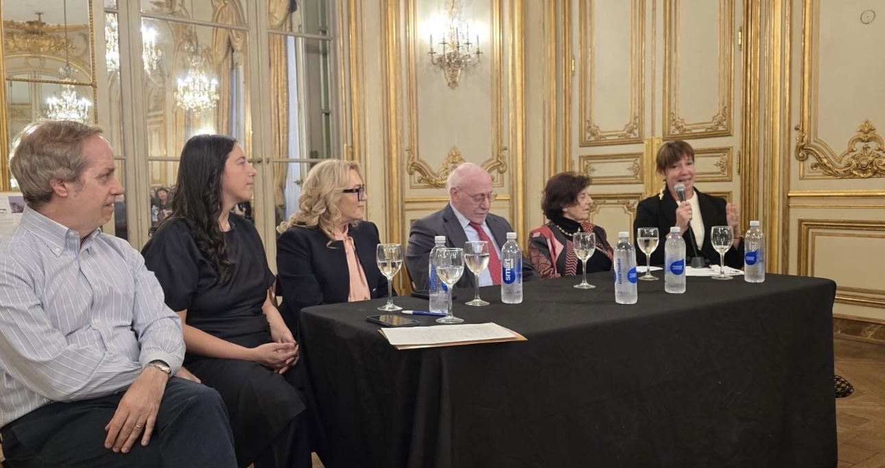Claribel Terré Morell con micrófono durante una mesa de conversación en un salón histórico