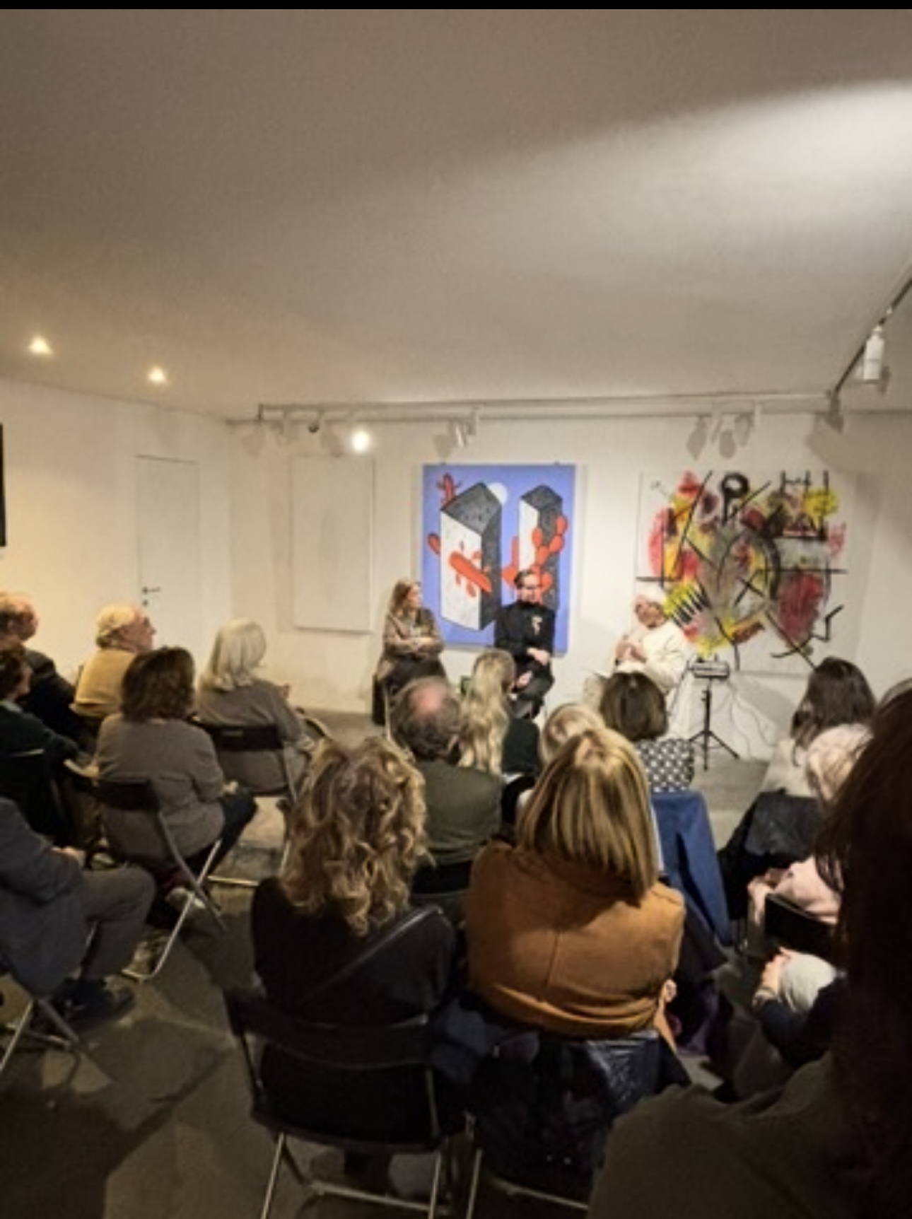 Conversación con público en una sala de exposiciones de arte contemporáneo