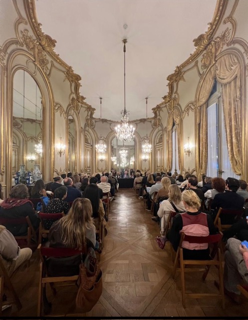 Público reunido en un salón histórico para una conversación sobre coleccionismo